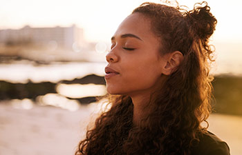 Benefits Of Online Therapy, woman breathing on beach