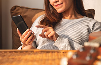 Benefits Of Online Therapy, woman using cell phone at home